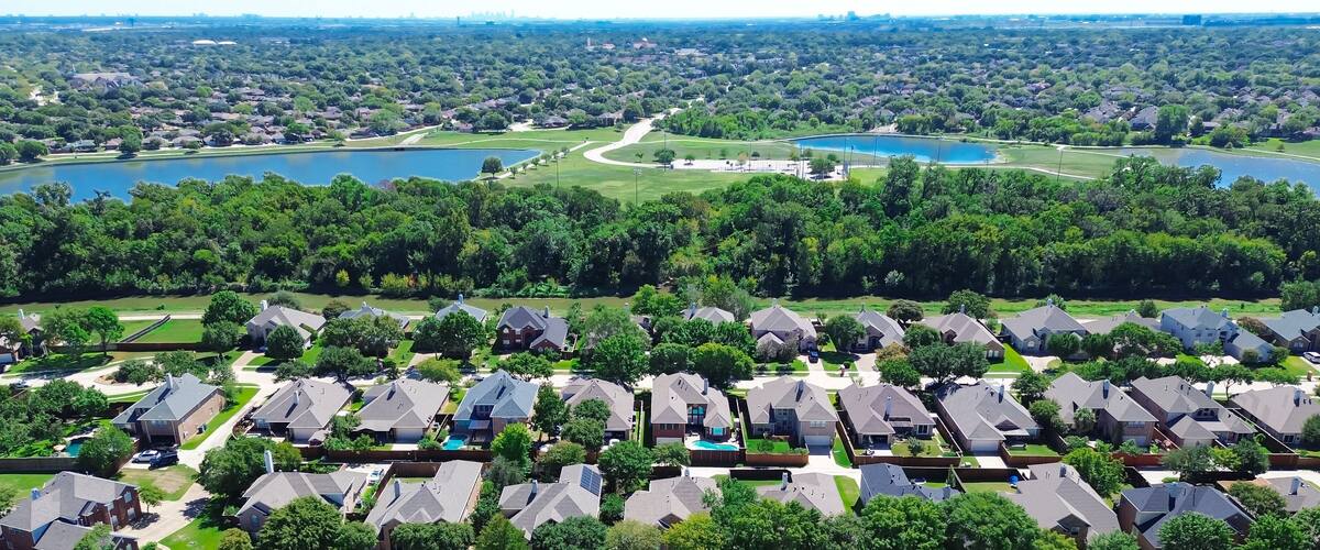 A residential area with houses, a golf course, and two lakes.