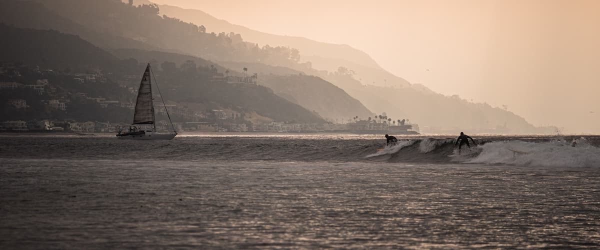 Surfboards and sailboats share the sea as the sun slips above the slopes along Malibu. #adventure #adventure photo contest #surfing #malibu #california #surf spots
