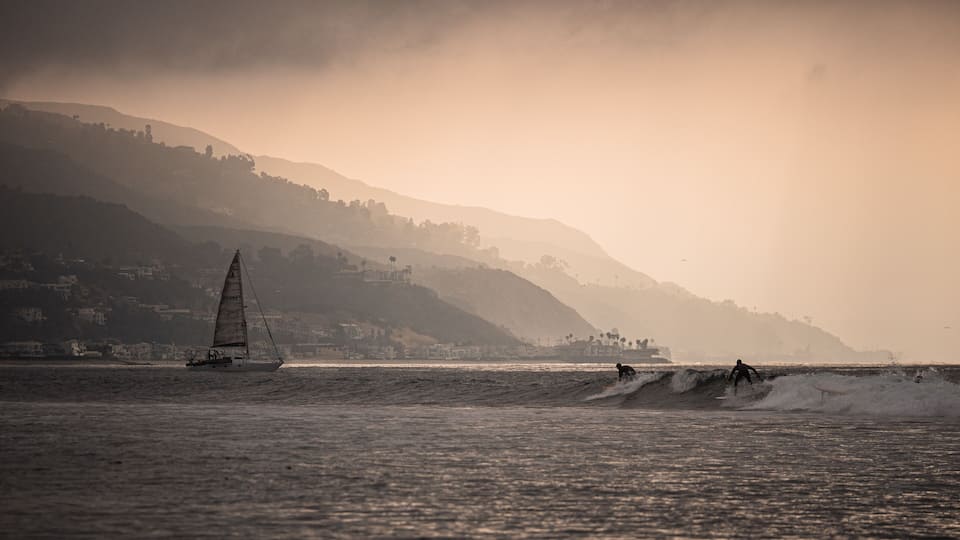 Surfboards and sailboats share the sea as the sun slips above the slopes along Malibu. #adventure #adventure photo contest #surfing #malibu #california #surf spots