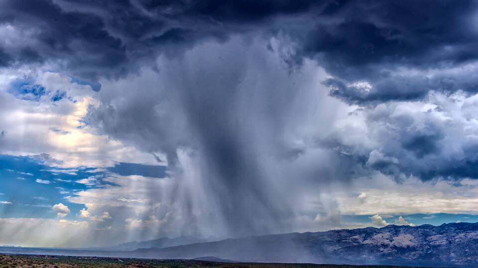 thunderhead cloud produces rain shower over semi-desert grassland prairie