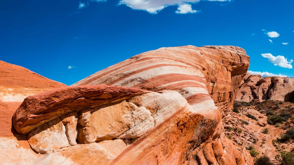 A large red rock formation with a prominent arch.