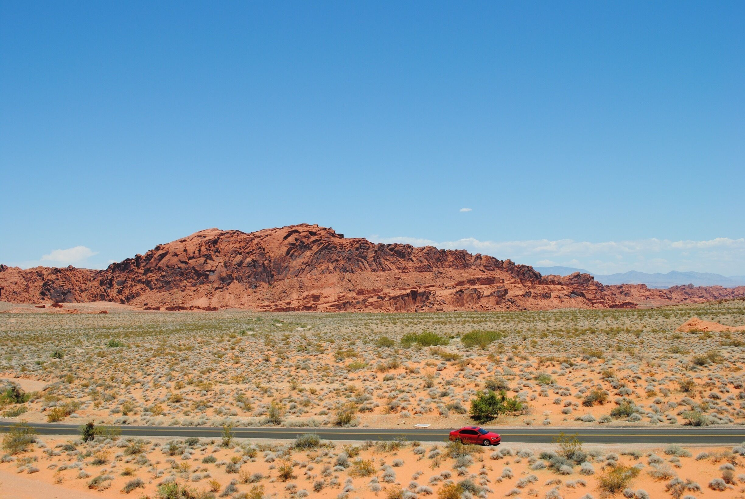 Here's a bit of a throwback. I took this picture in 2012. It's in the Valley of Fire State Park in Nevada. I love this picture because of the contrast of the blue sky and the reddish rocks.  The way the little red car looks compared to the rest of it's surroundings puts things into perspective! 
