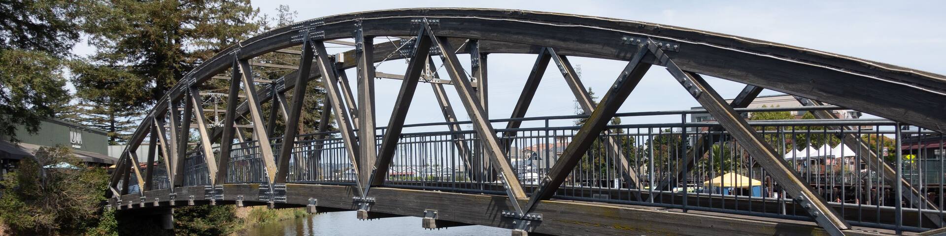 A steel bridge over a river with a metal railing.
