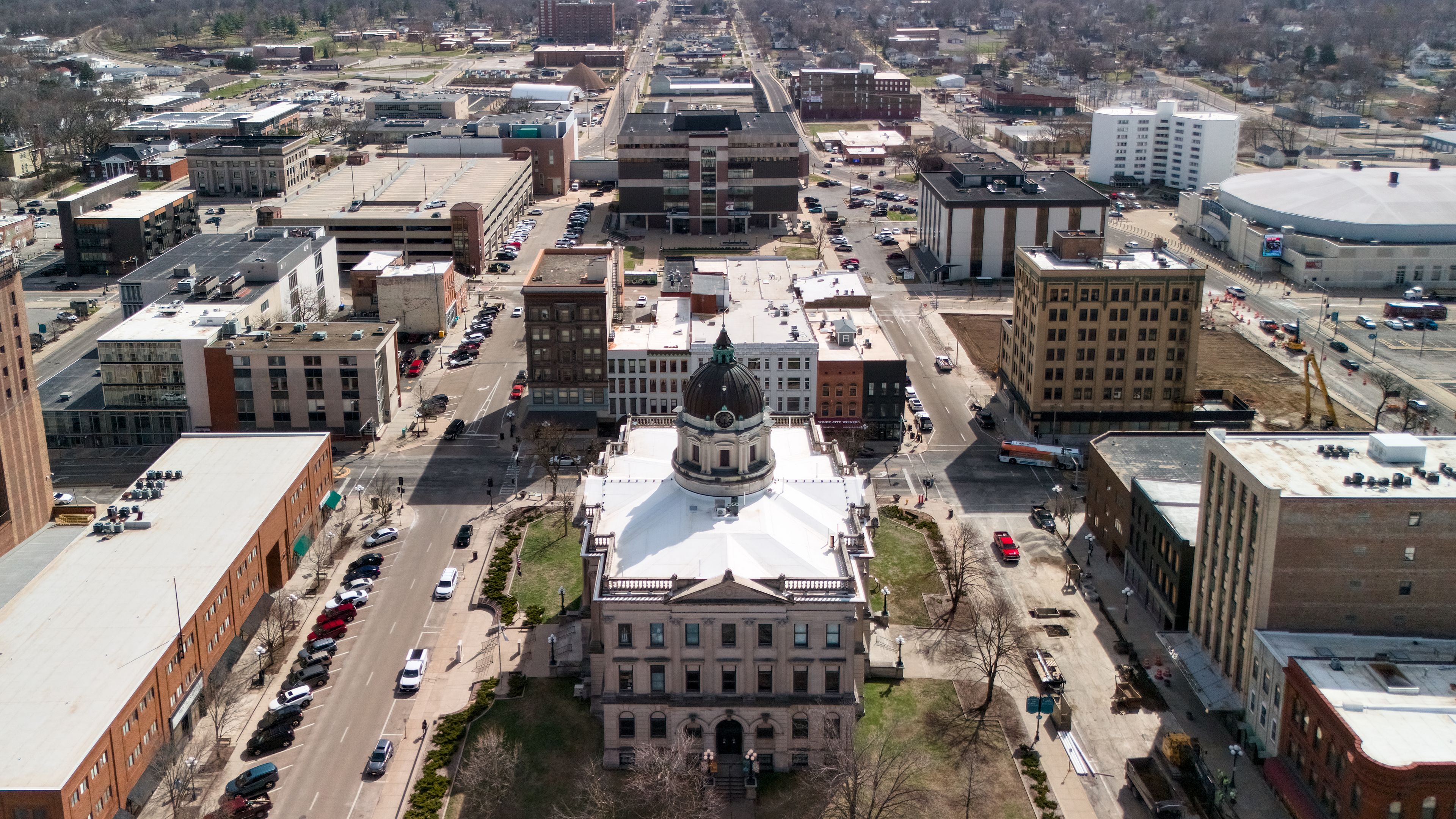 A cityscape with a prominent historic building with a dome, surrounded by modern buildings and busy streets.