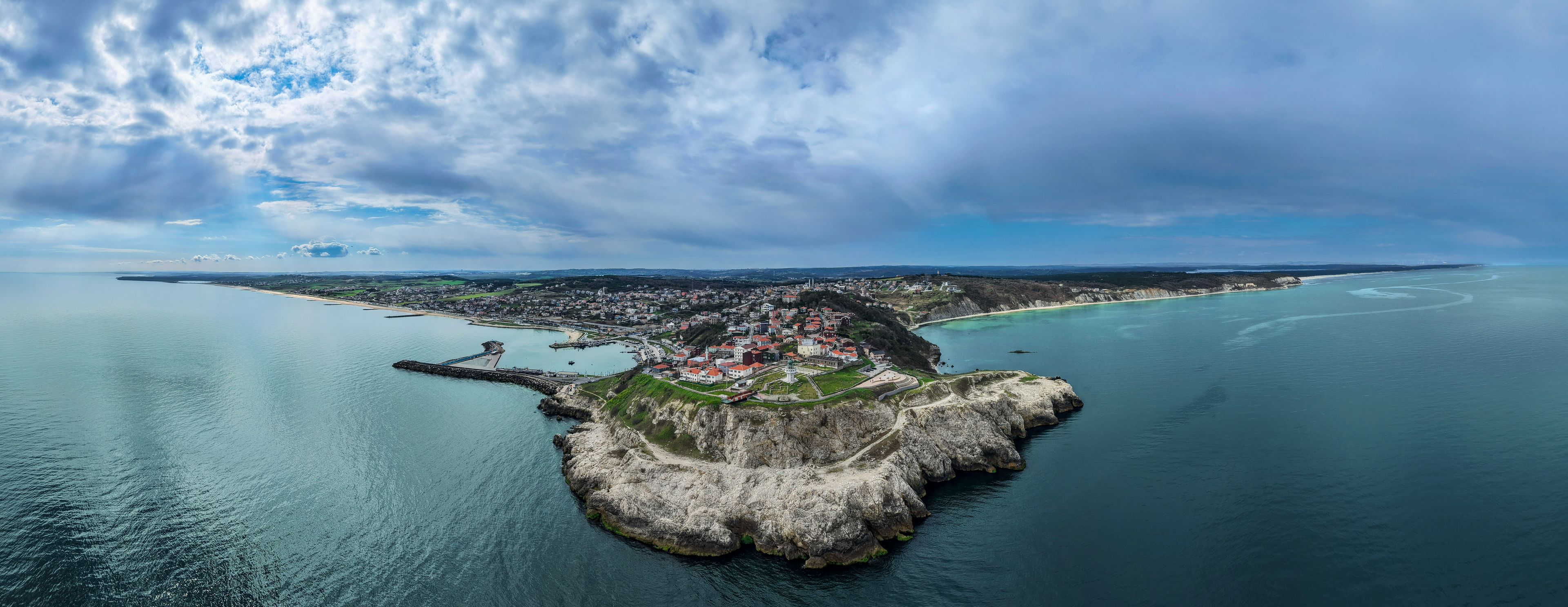 A spectacular wide aerial panorama of Karaburun coastal village and its rocky peninsula stretching into the sea in Arnavutkoy, Istanbul. 