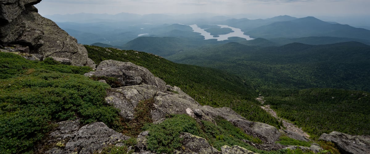 A mountainous landscape with rocky outcrops and dense forest.