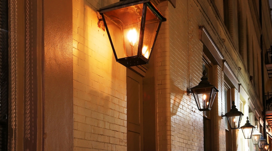 New Orleans French Quarter gas lights. Night street view with glowing real gas lanterns on the outdoor wall one of the building in the famous French Quarters, New Orleans, Louisiana, USA.