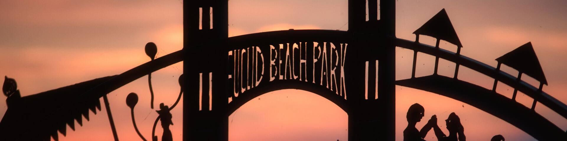 A silhouette of a park entrance with the name 'JULIUS BEACH PARK' and a lamp post.
