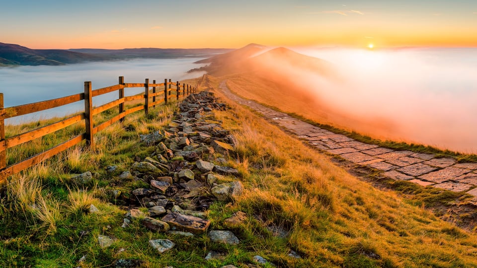 Panoramic sunrise view of beautiful cloud inversion in Peak District valley. Taken at Mam Tor.