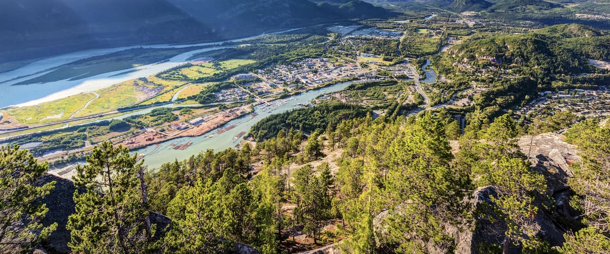 A mountainous landscape with a river flowing through a town.