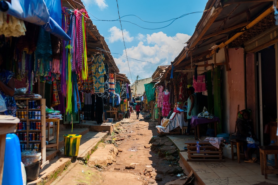 view of colorful open air street market in doula cameroun during sunny day with traditional clothes