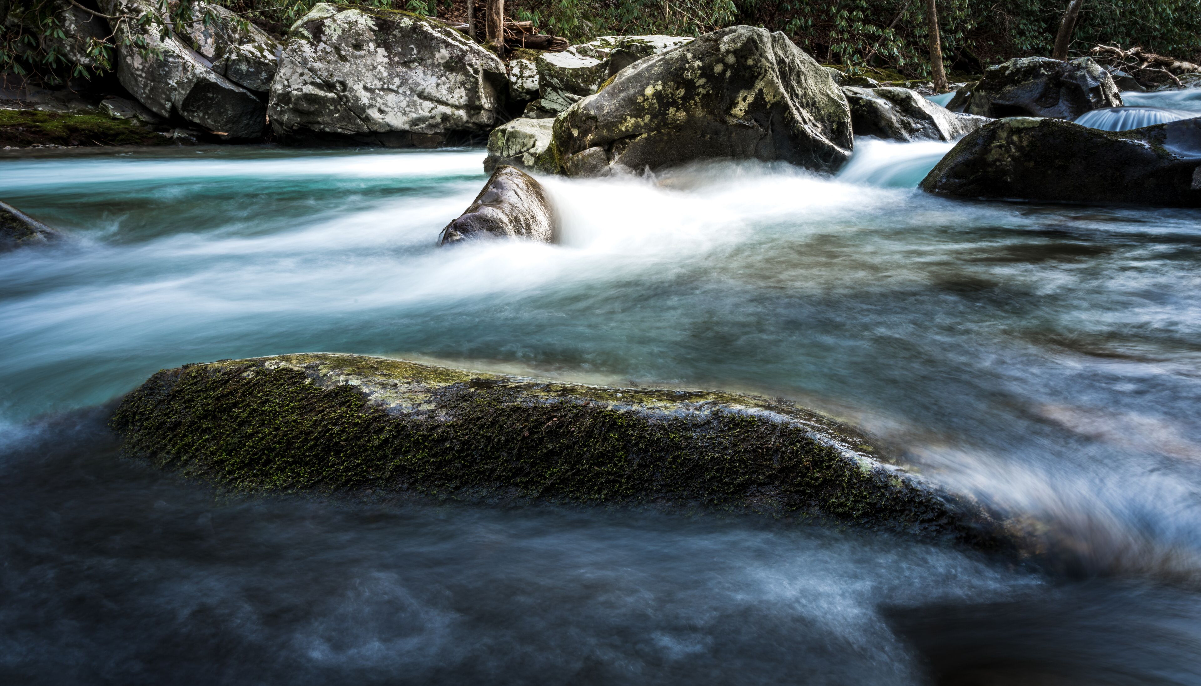 Mossy Rocky Peaks Above River Water