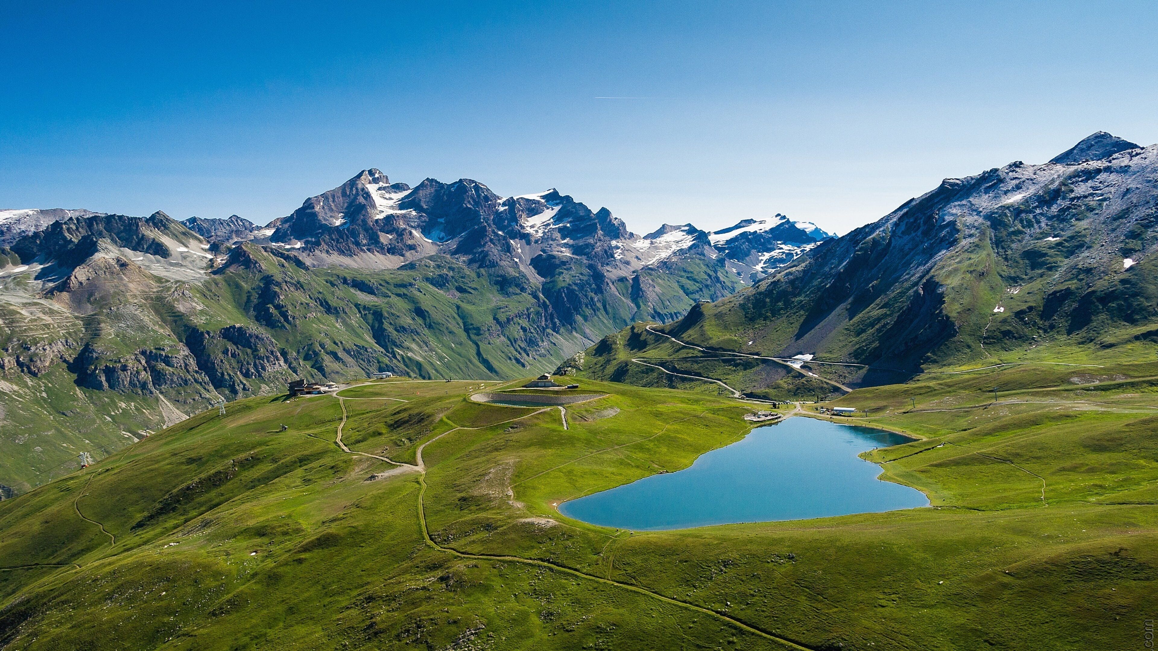 A mountainous landscape with a lake and winding roads.