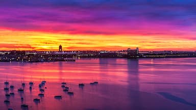 Un atardecer sobre un puerto con barcos y edificios.