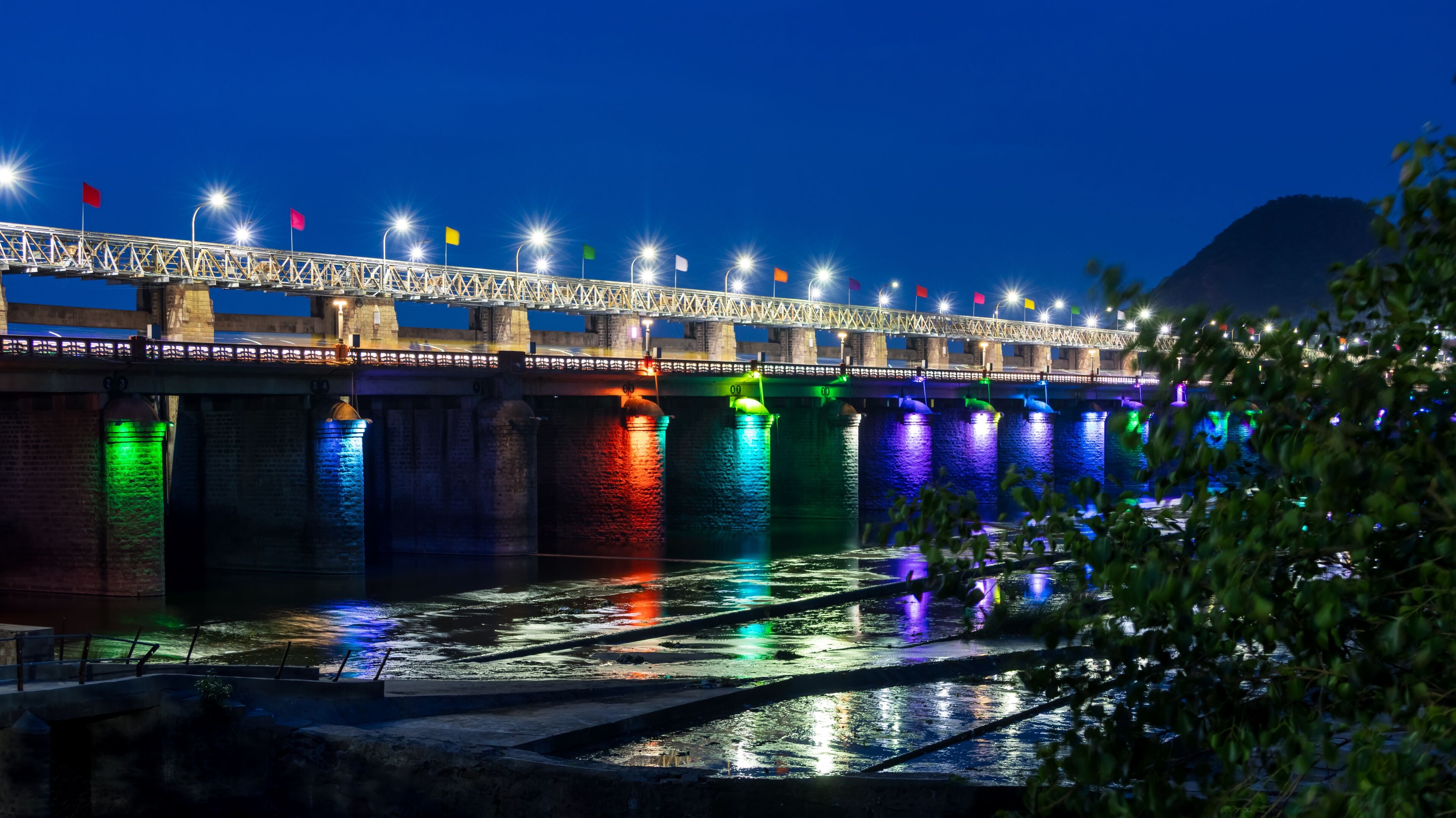 Historic Prakasam Barrage illuminated with colorful lights in the night time, Vijayawada, Andhra Pradesh, India.