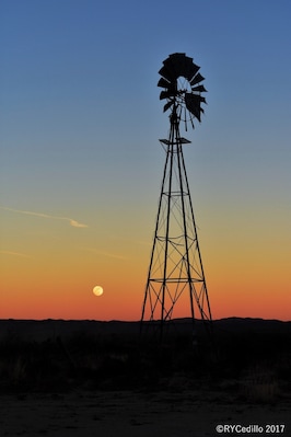 Un molino de viento silueteado contra un cielo al atardecer.