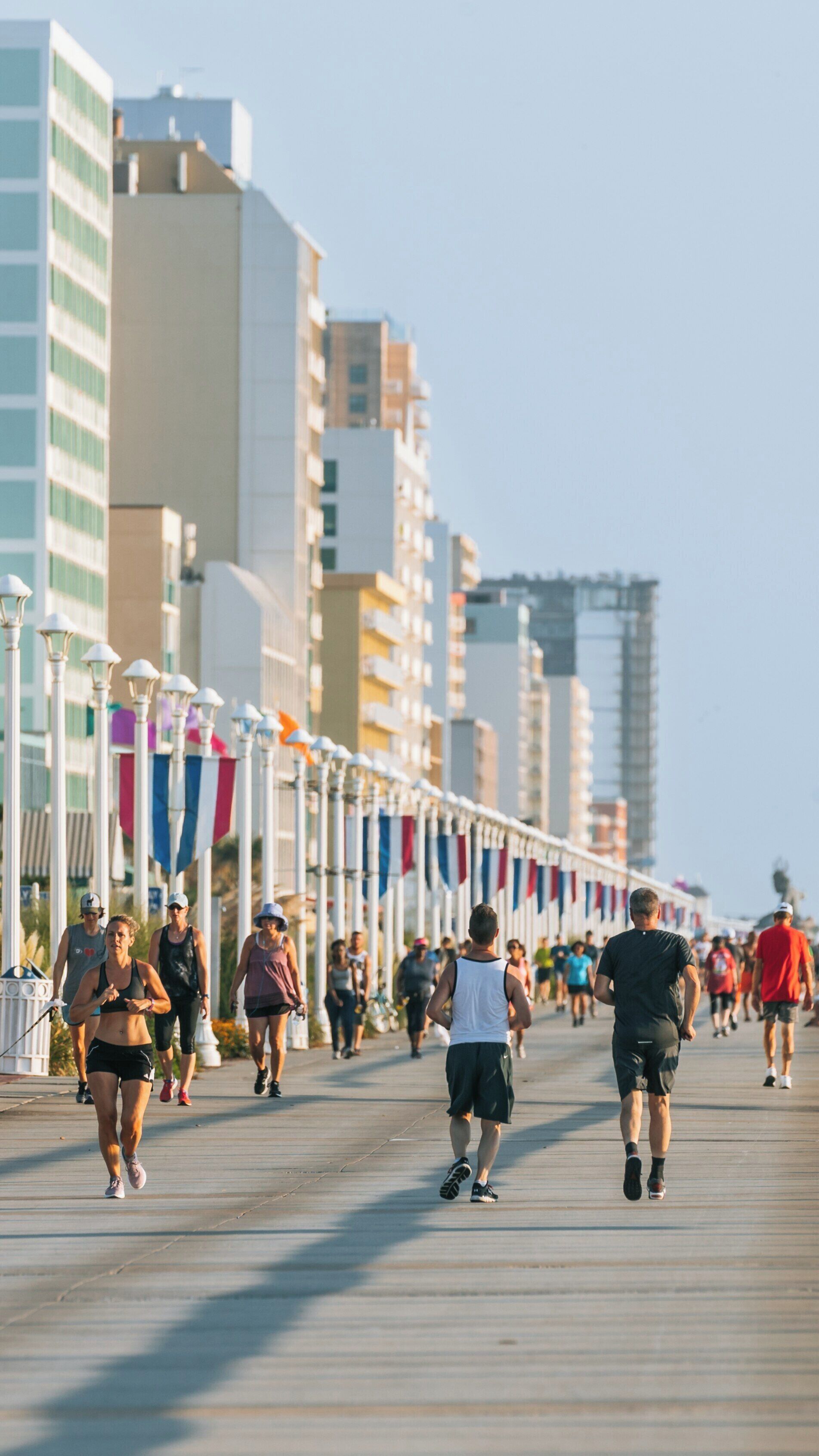Vibrant activity along Virginia Beach Boardwalk showcases locals and visitors enjoying a sunny day near the ocean