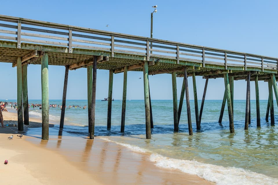 Ein Strand mit einer hölzernen Steg, der sich ins Meer erstreckt.