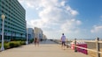 Un paseo marítimo con playa, una fila de hoteles y un cielo despejado.