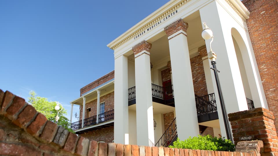 A corner medical center with white columns, brick walls, and a balcony with black railings.