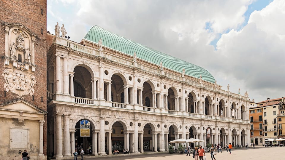 A historic building with a green dome and classical architecture.