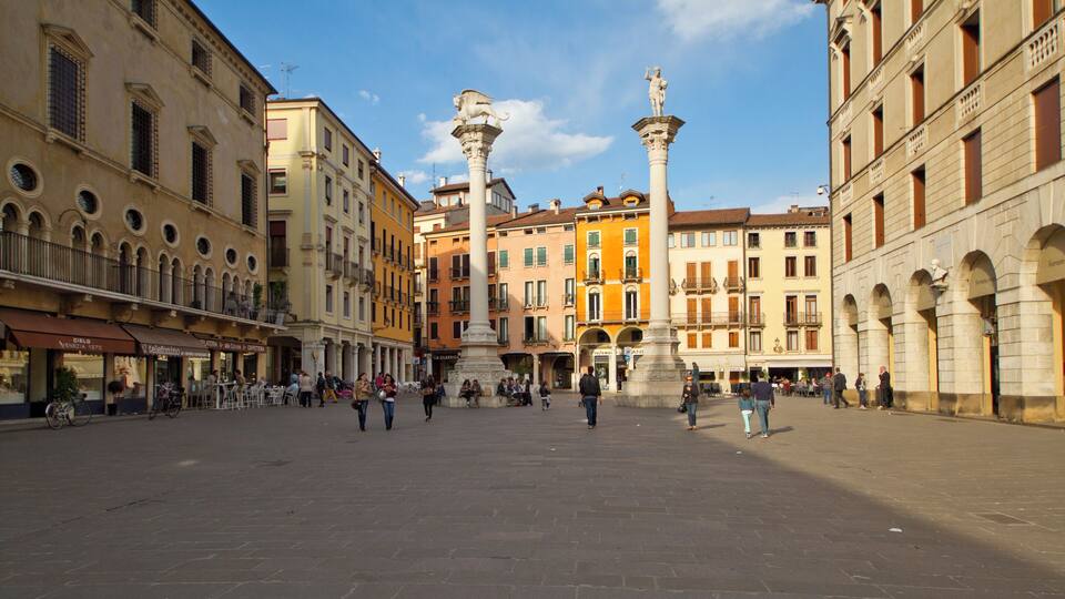 A historic square with a central monument, surrounded by colorful buildings and cafes.