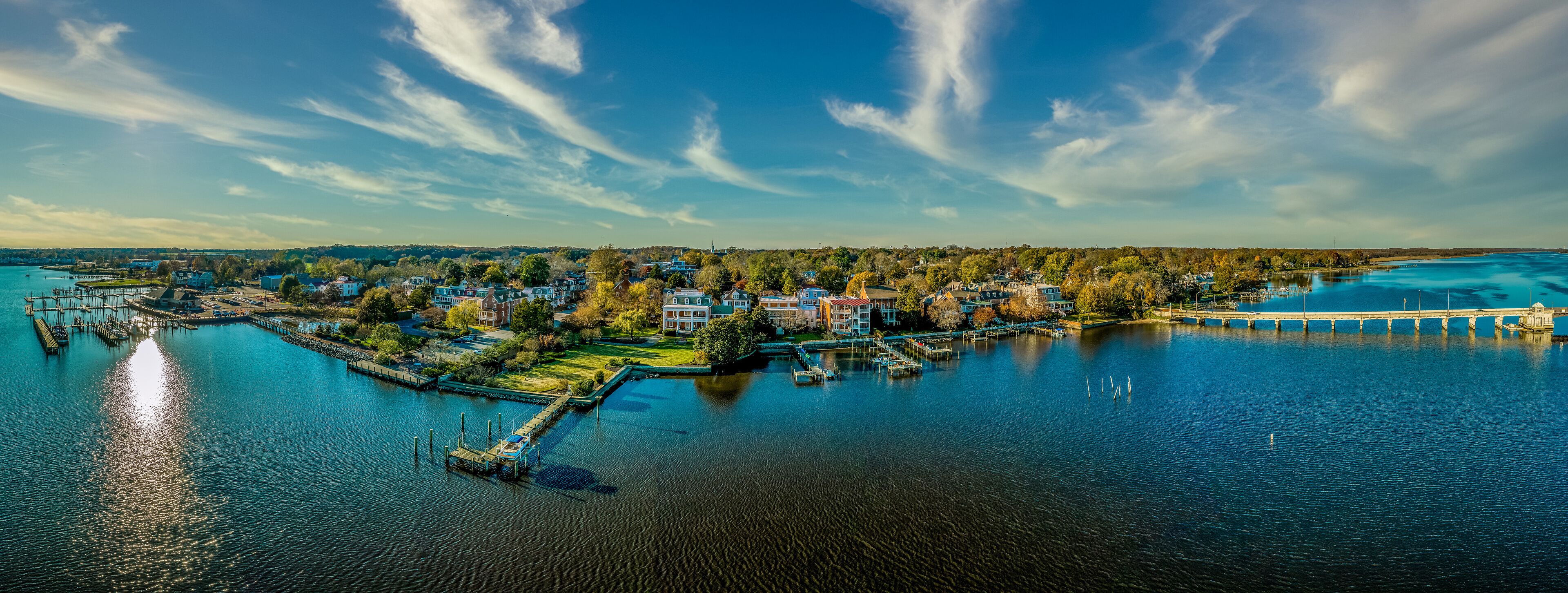 A waterfront town with a pier, dock, and several buildings.