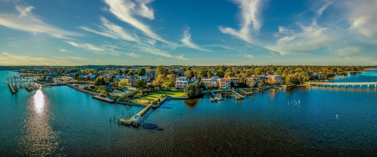 A waterfront town with a pier, dock, and several buildings.