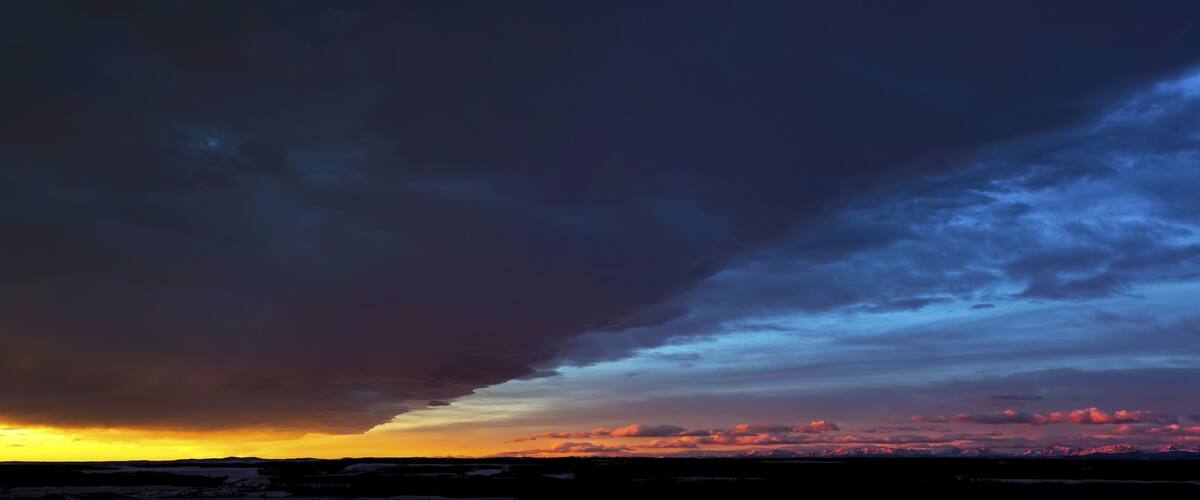 Ein dramatischer Himmel mit einer Mischung aus dunklen Wolken und einem Sonnenuntergang.