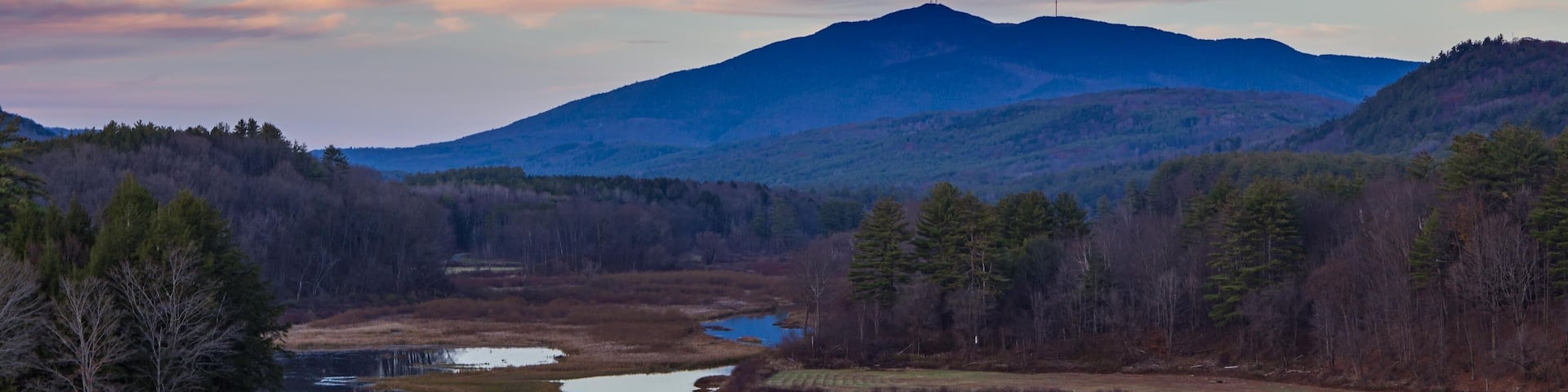 Mount Ascutney and sunset pink cloud reflections in the North Springfield Reservoir near Weathersfield, Vermont.