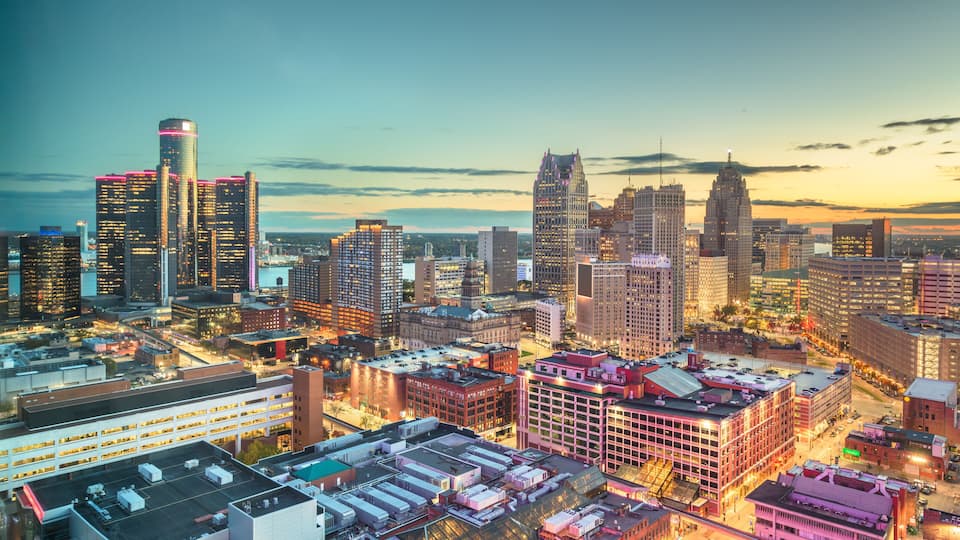 A cityscape with high-rise buildings, a prominent skyscraper with a distinctive top, and a mix of modern and older architecture.