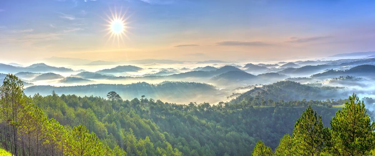 A mountainous landscape with dense forests and a valley.