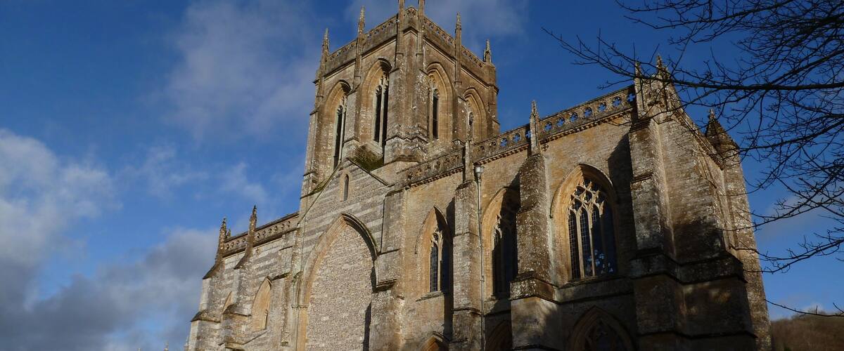 A historic stone church with arched windows and a tall tower.
