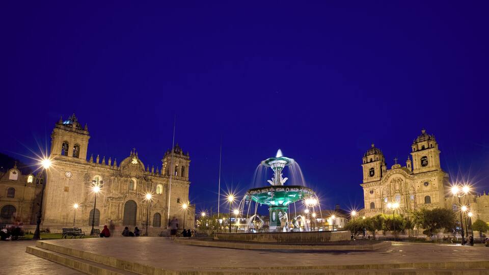 Plaza de Armas illuminated at dusk in the town center of Cusco, Peru.