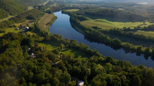 A 6:15 a.m. departure from Post Mills Airport, VT in your hot air balloon gets this spectacular view of Vermont to the left of the river, and New Hampshire to the right. This perspective is looking essentially northwards. Farm lands and forest nestled along what was in colonial times a mighty river of commerce and transportation. When Vermont separated from NH, and to protect those assets, NH insisted the border between NH and VT would be the high water mark on the westerly side of the river.