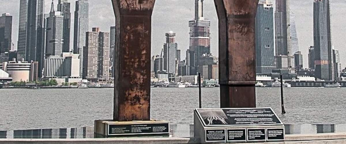 9/11 Memorial - The massive steel tridents salvaged from the World Trade Center site rests above an infinity pool in Weehawken New Jersey. They stretch majestically skyward against the backdrop of the Hudson river and New York city skyline. These steel tridents which are two of the 13 that survived the wreckage will forever symbolize the connection between Weehawken and the World Trade Center. This is the site where more than 60,000 people were evacuated to on that fateful day. It also commemorates the five people who perished in the tragedy who were residents of Weehawken.