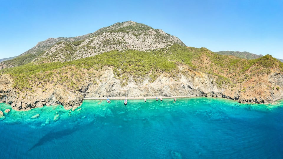 A mountainous island surrounded by turquoise waters.