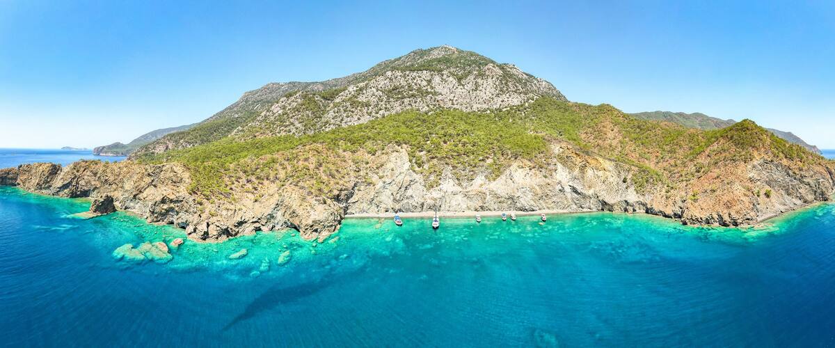 A mountainous island surrounded by turquoise waters.