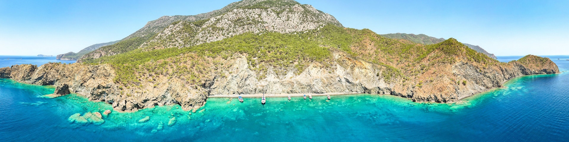 A mountainous island surrounded by turquoise waters.
