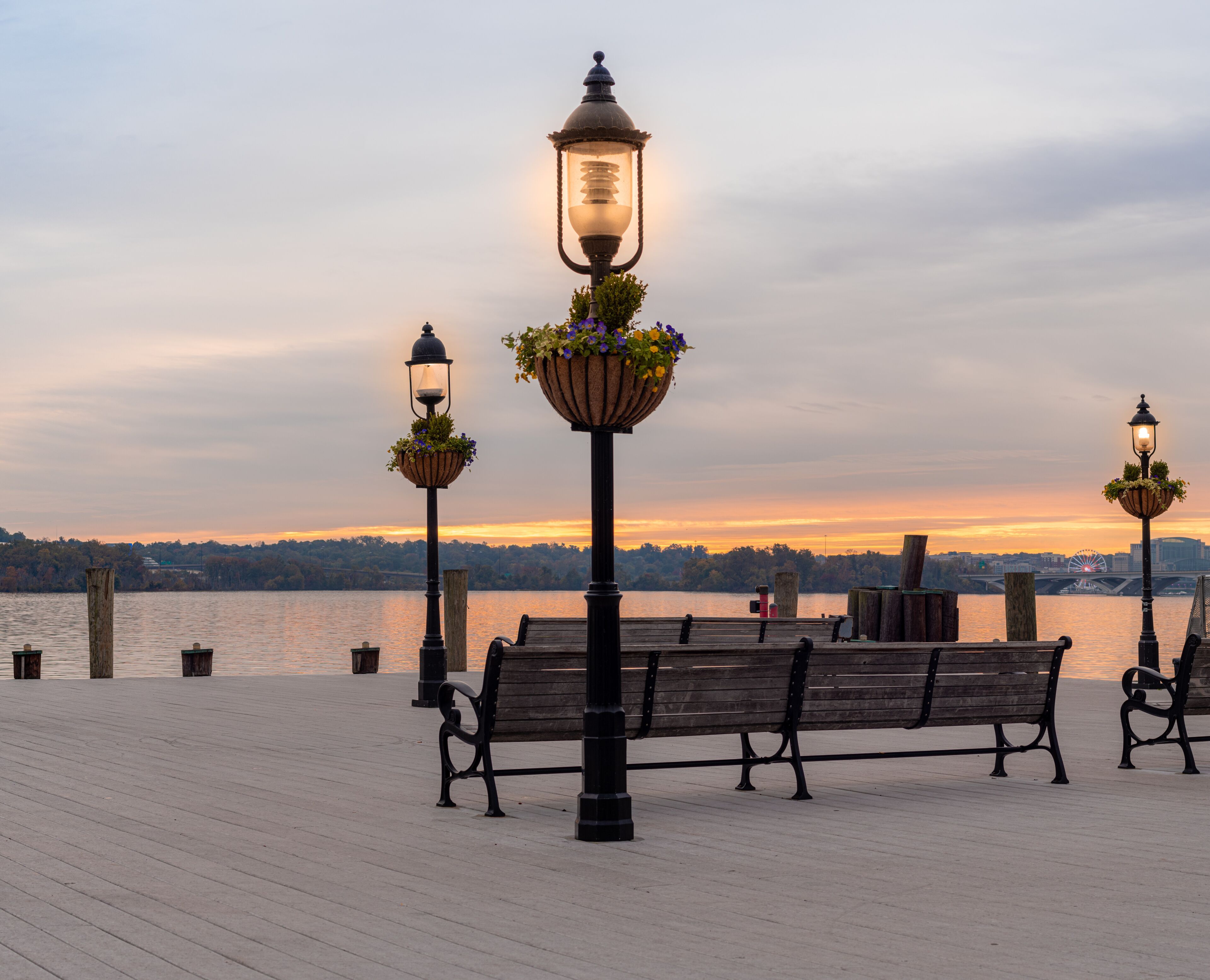 Street Lights on a Dock with Benches Overlooking a River and Colorful Sky