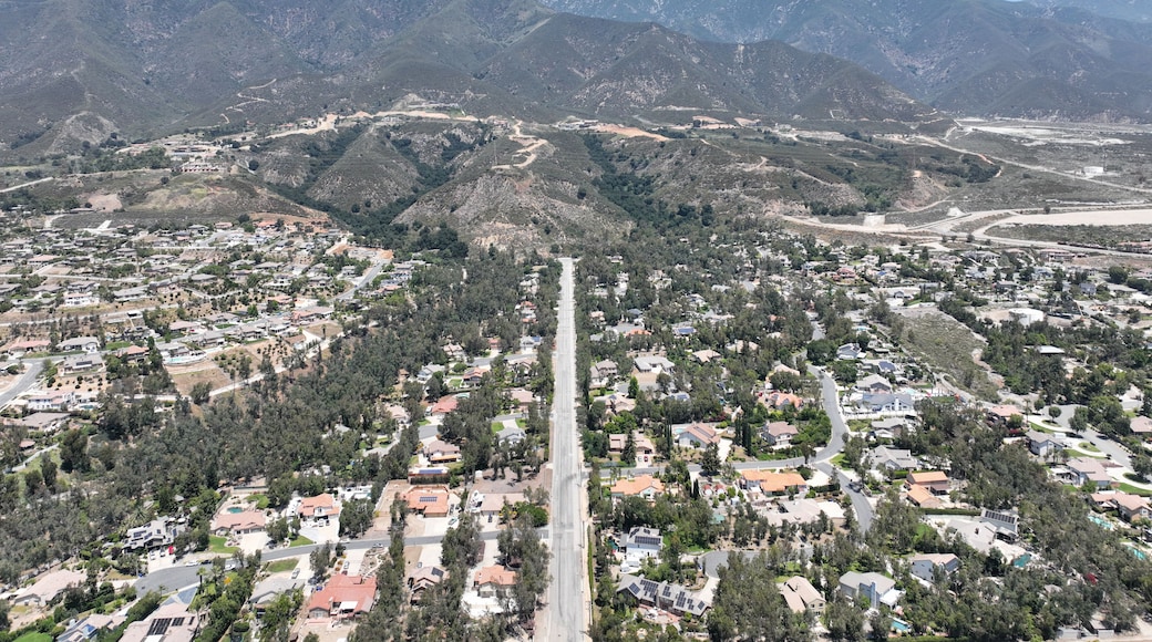 A residential area with houses, roads, and mountains in the background.