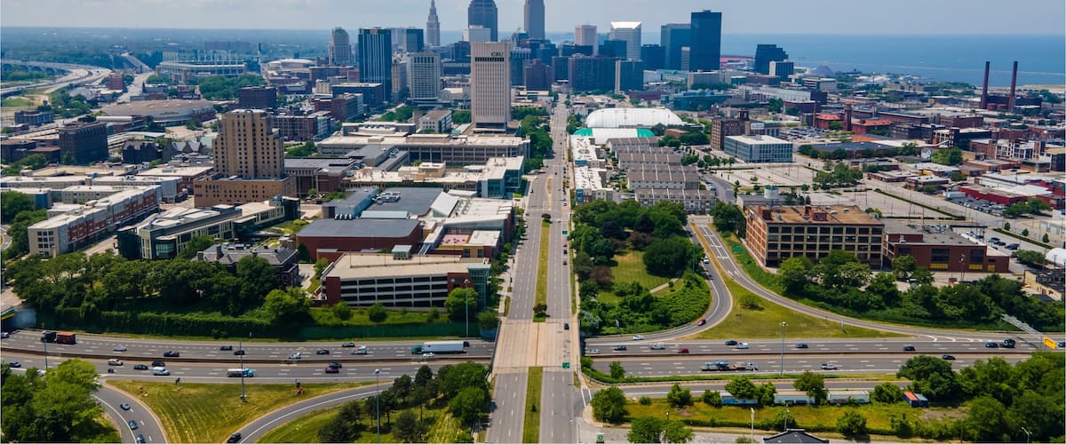 A cityscape with a prominent skyscraper, a bridge, and a highway.