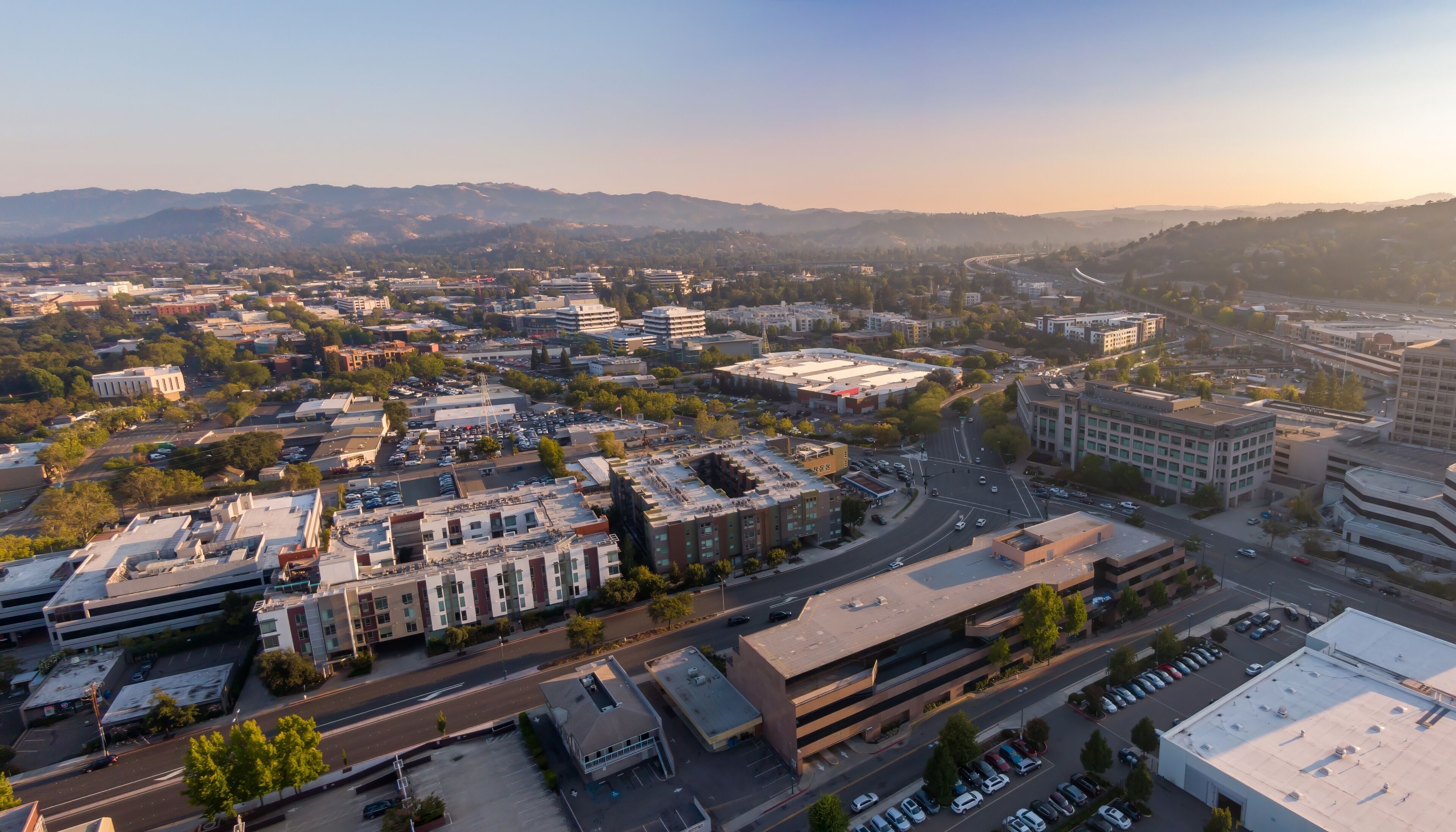 Aerial view of Walnut Creek, California, USA, showcasing the urban landscape with buildings, roads, and distant hills during a sunny day. Illustrates city planning and development.