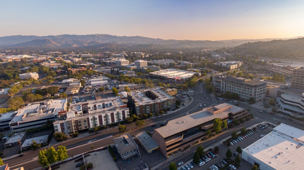 Aerial view of Walnut Creek, California, USA, showcasing the urban landscape with buildings, roads, and distant hills during a sunny day. Illustrates city planning and development.