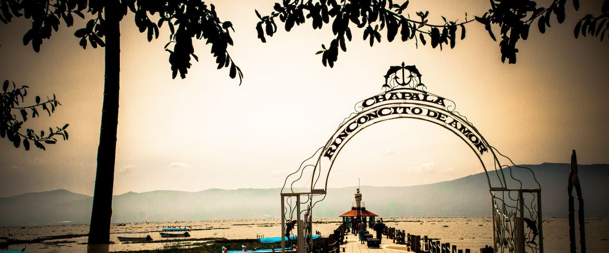 A beachside promenade with a sign reading 'CHAPALA RONCONO DE AMOR.'