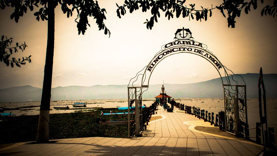 A beachside promenade with a sign reading 'CHAPALA RONCONO DE AMOR.'