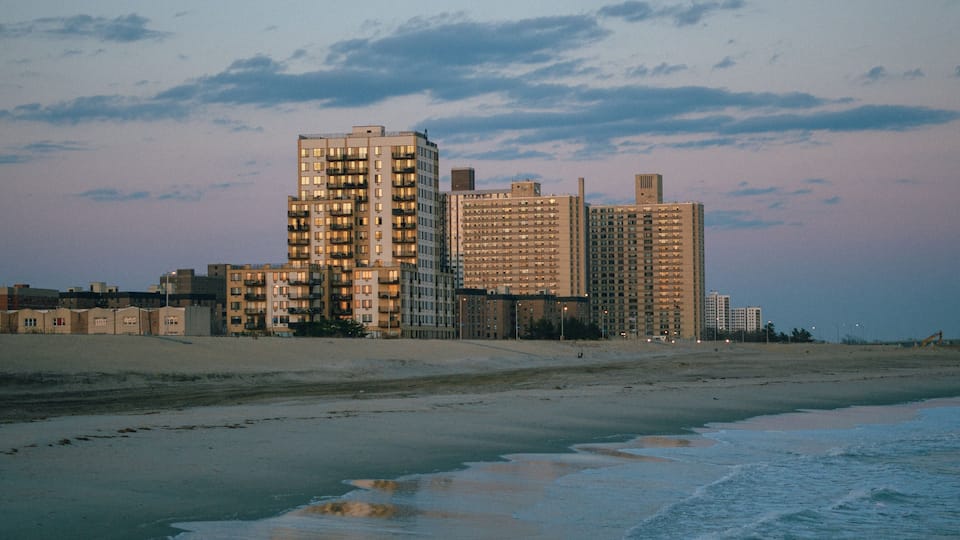 A beachfront with high-rise buildings and a clear sky.