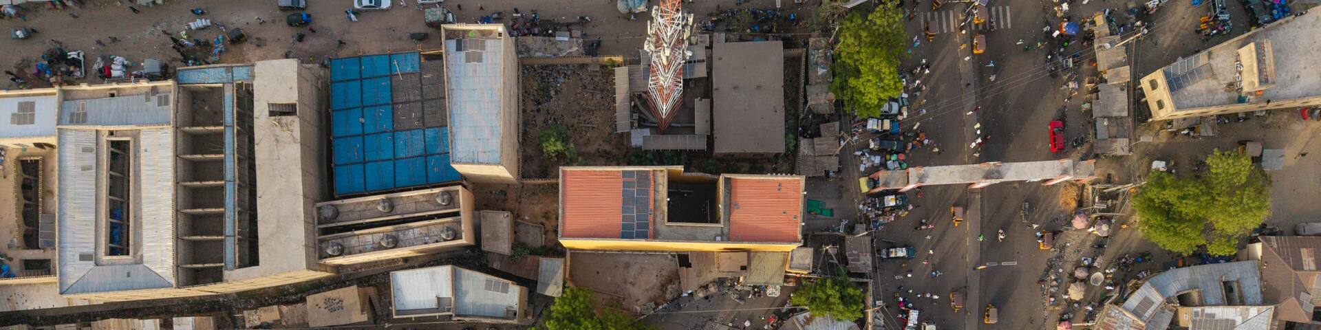 Aerial view of the historic city of Kano, featuring dense urban architecture, flat-roofed buildings, a prominent communication tower, and busy streets, Kano, Kano, Nigeria.