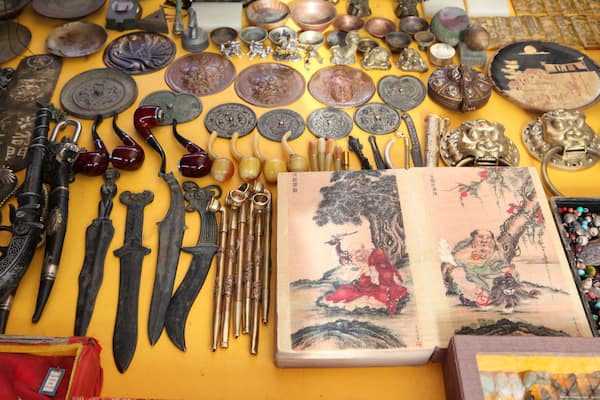Naran Tuul Market in Ulaanbaatar city, Mongolia. Antique goods on flea market: aancient book, smoking pipe, knives, other antique, antiquarian things. Bazaar