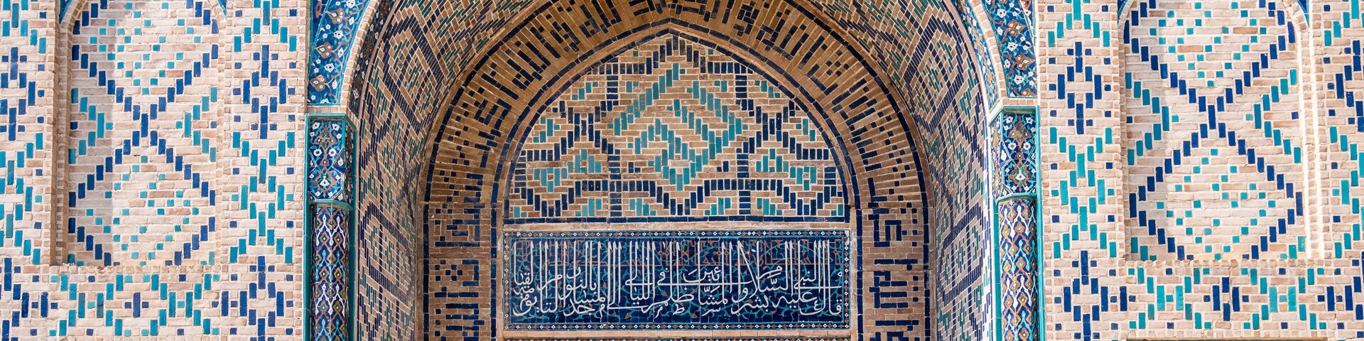 Un arco detallado con labor de azulejos intrincados y caligrafía árabe.